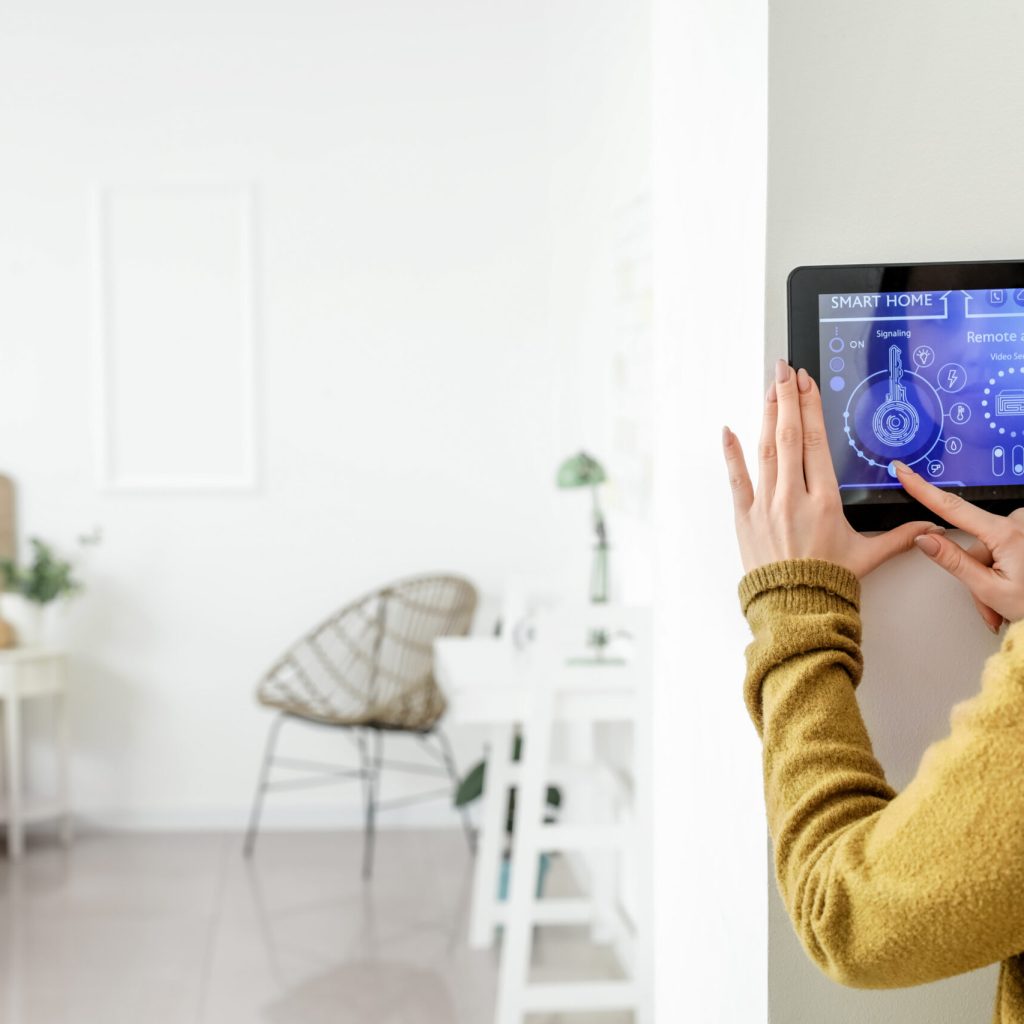 Woman using smart home security system control panel
